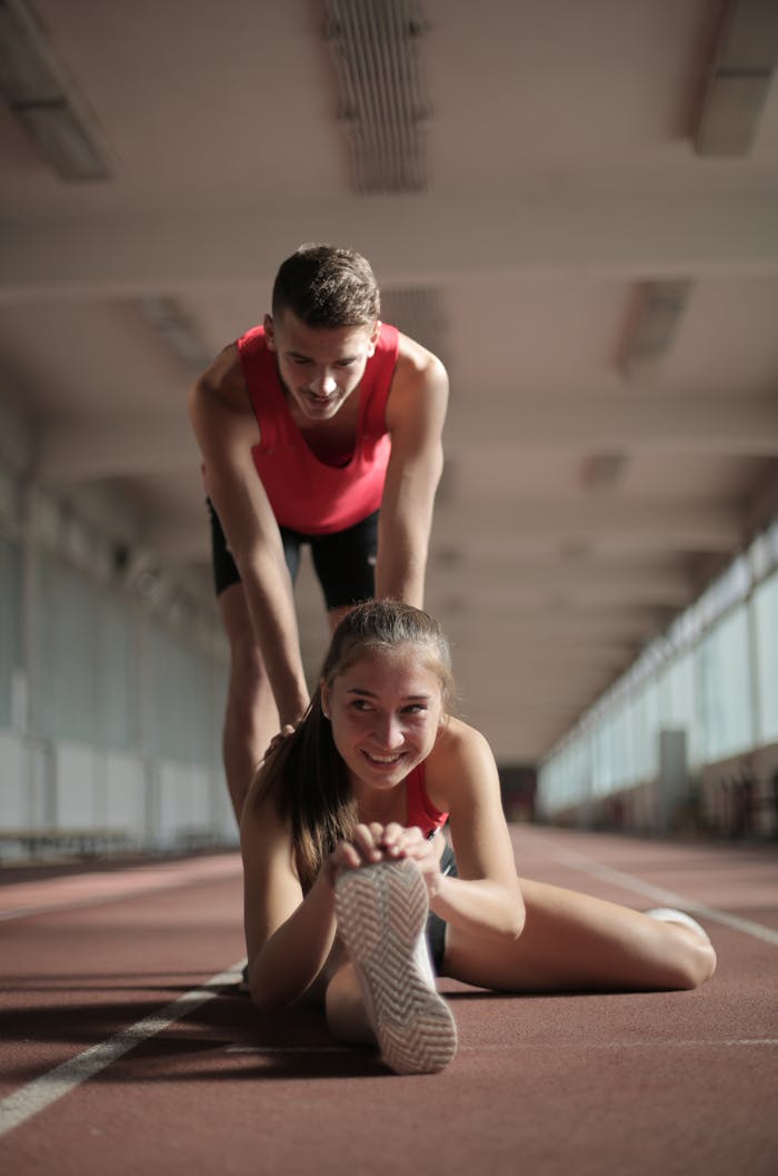 Athletic man and woman stretching together indoors, promoting fitness